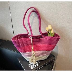 Detail of gradient pink woven straw tote bag with wood bead and tassel accessory