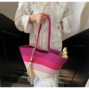 Detail of gradient woven straw tote with colorful fringe tassel and wooden beads decoration