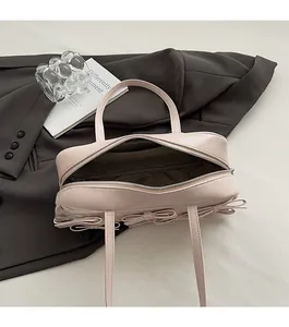Detail view showing smooth zipper closure and spacious interior lining of the pink bow handbag