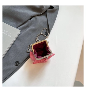 Detail of pink mini bow bag showing metal clasp and purple fabric lining inside