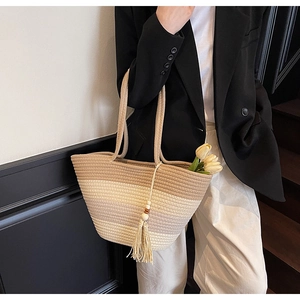 Detail of hand-woven straw tote with gradient color design and wooden bead tassel decor