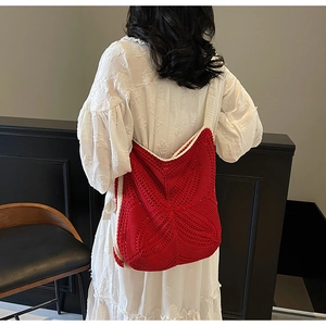 Close-up of red crochet shoulder bag with hollow knit texture and contrast trim details