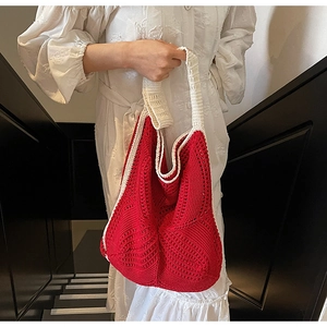 Macro shot of red and white handcrafted crochet knit texture on a hollow hobo bag