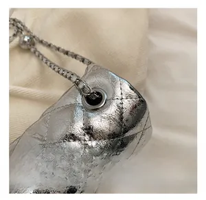 Détail des œillets métalliques et de la bandoulière sur sac matelassé argenté