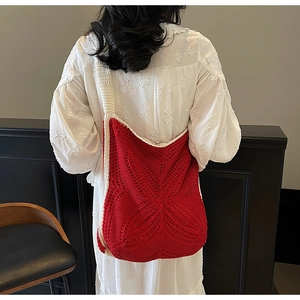 Detailed close-up of red and beige star-patterned crochet knit hobo shoulder bag