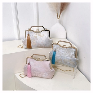 Close-up of vintage jacquard kiss-lock handbags with silk tassels and floral patterns