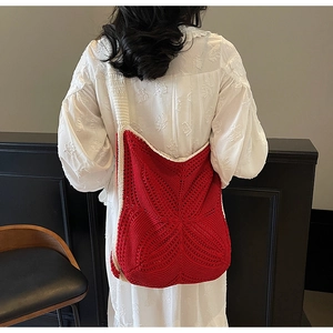 Detail of red handmade crochet star-pattern tote with off-white shoulder strap