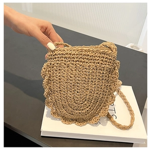 Dettaglio del bordo a conchiglia e cerniera sulla borsa da spiaggia in paglia intrecciata