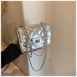 Détail d'un sac bandoulière argenté matelassé avec finition métallisée