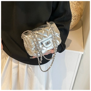 Détail du sac bandoulière argenté matelassé avec chaîne en métal et fermoir rotatif