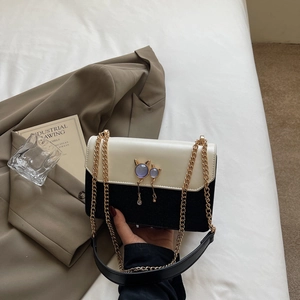 Sac bandoulière chic noir et blanc avec boucle chat et bandoulière chaîne dorée