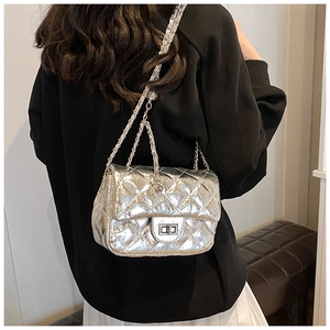 Détail du sac bandoulière argenté matelassé avec chaîne et fermoir pivotant
