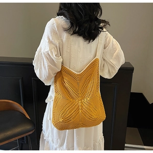 Detail of a bright yellow hand-woven crochet tote bag with intricate star-shaped knit pattern
