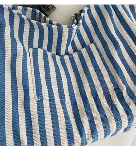 Detail shot of the front pocket and textured blue and white striped canvas material