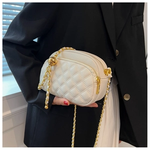 Detail of off-white quilted crossbody bag with gold chain and spherical buckle detail