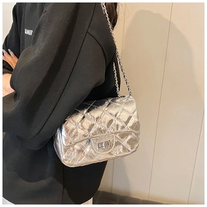 Détail du sac bandoulière argenté matelassé avec un fermoir rectangulaire tournant