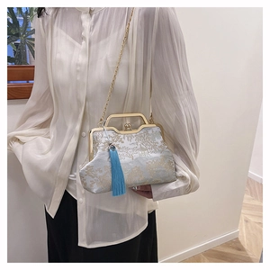 Detailed embroidery view of a light blue Qipao bag with gold frame and tassel