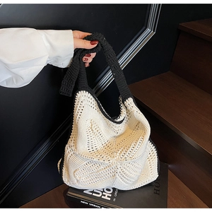 Close-up of black and white hand-crocheted tote bag showing 3D honeycomb knit texture