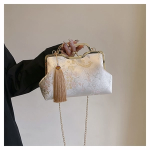 Detail of floral embroidery on cream satin handbag with vintage gold metal frame