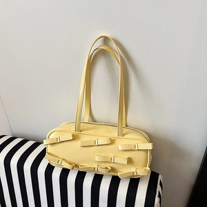 Retro cream yellow shoulder bag with decorative bows on smooth synthetic leather
