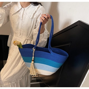 Detail of bohemian gradient blue woven straw tote bag with wood bead tassels and tulips