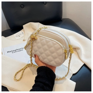 Chic beige quilted crossbody bag with golden chain strap and ball charm accent