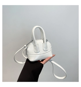 Gros plan détaillé d'un mini sac bandoulière blanc en cuir verni brillant à la main