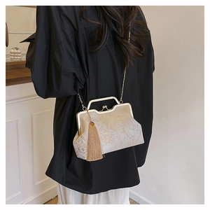Detail of vintage champagne evening bag with floral embroidery, chain strap and long tassel