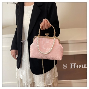 Pink evening bag with floral embroidery, pearl handle, and elegant gold chain detail