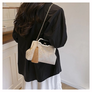 Detail of vintage embroidery handbag with golden chain strap and silk tassels decoration