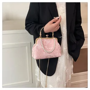 Detailed view of pink floral jacquard fabric with pearl handle and golden clasp