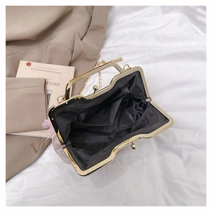 Detail view of pink vintage handbag interior with golden clasp and black fabric lining