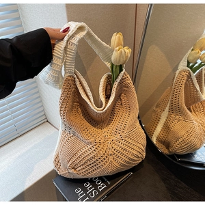 Detail of hollow-out knit tote bag with brown crochet patterns and white wide shoulder strap