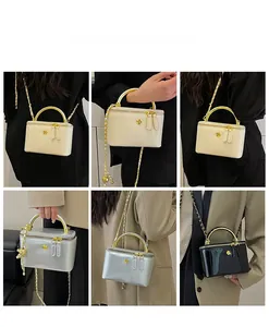 Glossy leather chain bag with metal handle and flower clasp in white, silver and black