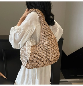 Detail of beige crochet straw bag featuring elegant white lace trim and hobo shoulder strap