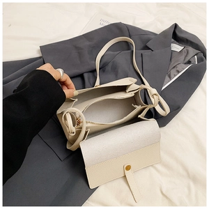 Détail du sac bandoulière beige clair avec texture grainée et rabat magnétique sûr