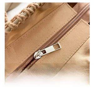 Macro di cerniera in argento e trama intrecciata su una borsa a tracolla in paglia