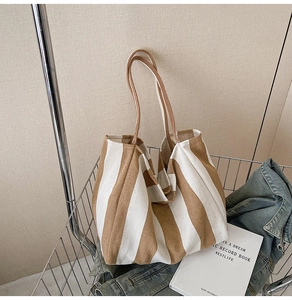 Detail of a large striped canvas tote bag inside a metal basket in a casual scene