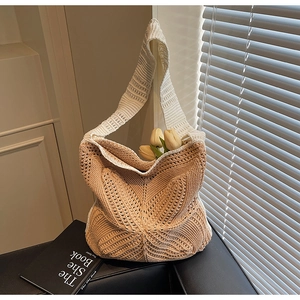 Detailed close-up of handmade hollow knit shoulder bag with beige woven leaf patterns