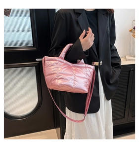 Close-up of pink quilted puffer bucket bag with metallic finish and shoulder strap