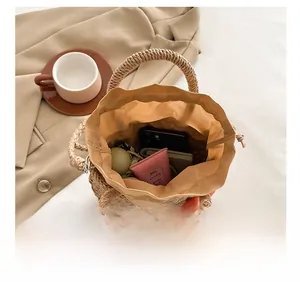 Top view of woven beige bucket bag interior capacity with drawstring lining and flower detail
