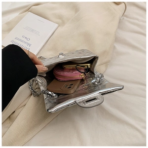 Détail du sac à chaîne argenté plissé montrant le rangement pour téléphone et objets