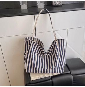 Close-up of blue and white striped canvas bucket bag with functional front pocket