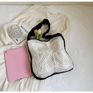 Detailed knit tote bag with hollow butterfly pattern and elegant lifestyle props