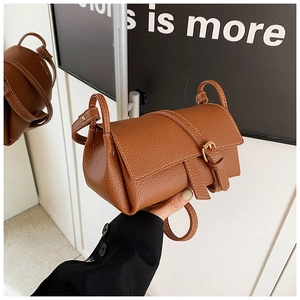 Gros plan du sac bandoulière caramel avec texture lychee et surpiqpiqures blanches