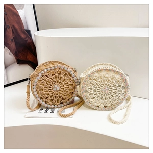 Dettagli di borse tonde boho fatte a mano con motivi floreali e tracolle intrecciate