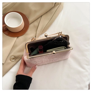Pink jacquard clutch bag with floral texture showing interior space for phone and lipstick