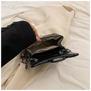 Vue intérieure du sac à bandoulière noir avec chaîne argentée et poche zippée