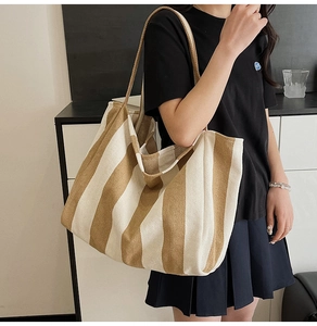 Detail view of striped canvas tote bag with thick rope handles and vintage texture