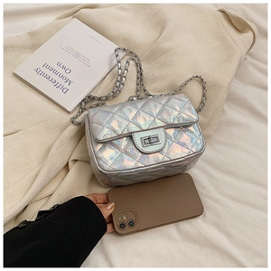 Détail du sac matelassé holographique argenté avec fermoir rotatif et smartphone